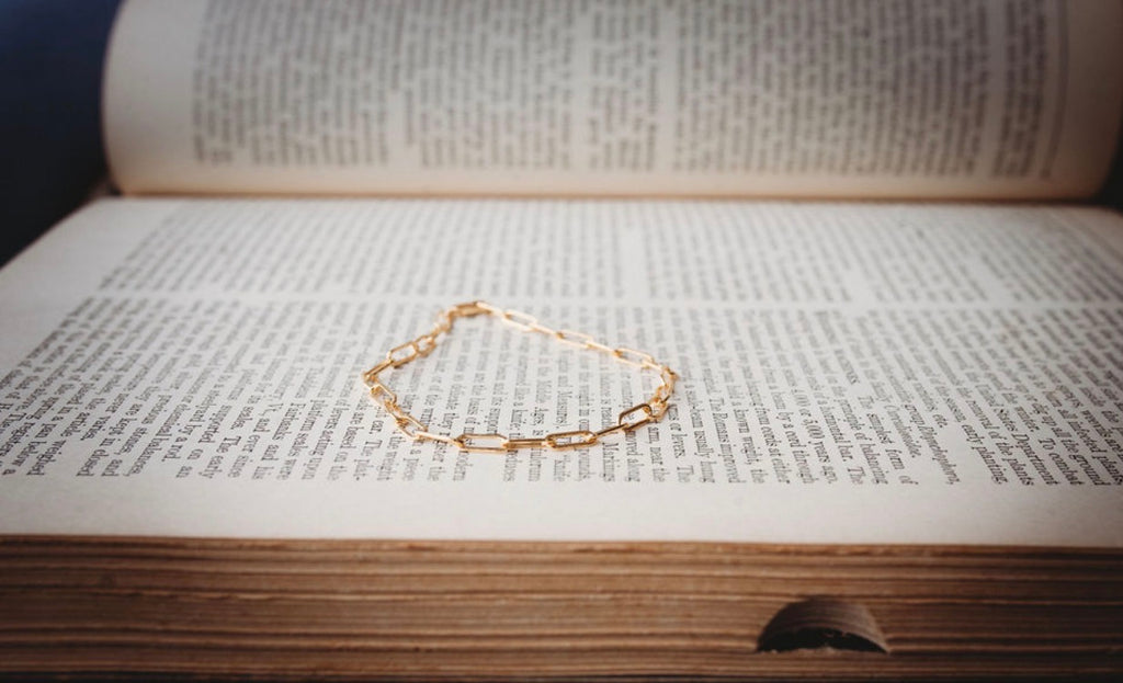 Large Gold paperclip bracelet on an open book