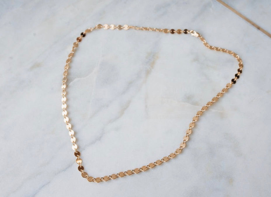 Thick Gold chain necklace on a marble surface