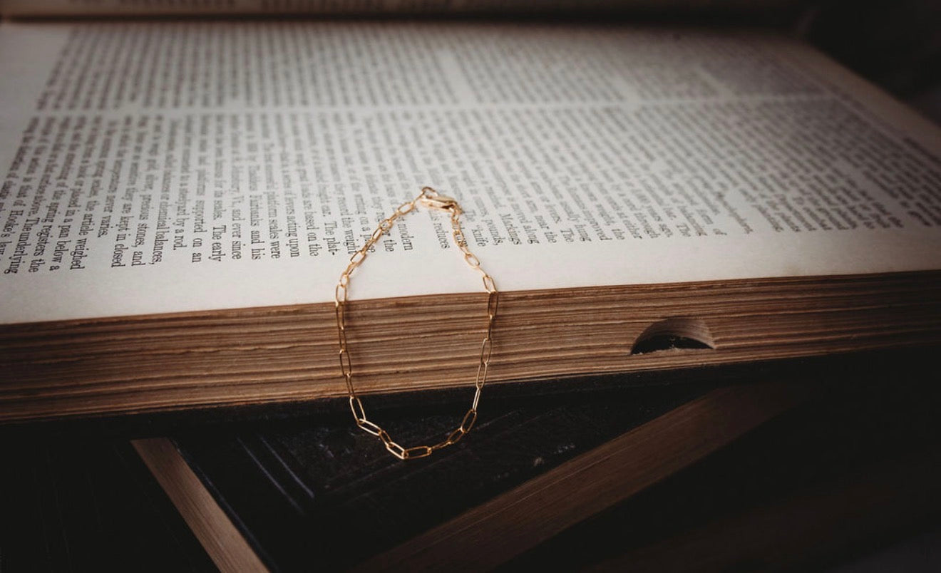 Small Gold paperclip bracelet on an open book