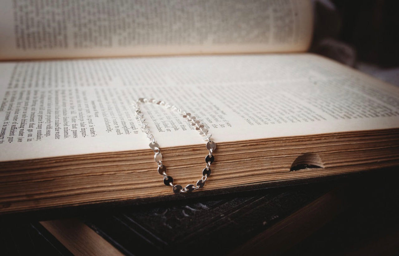 Thick Silver bracelet on an open book