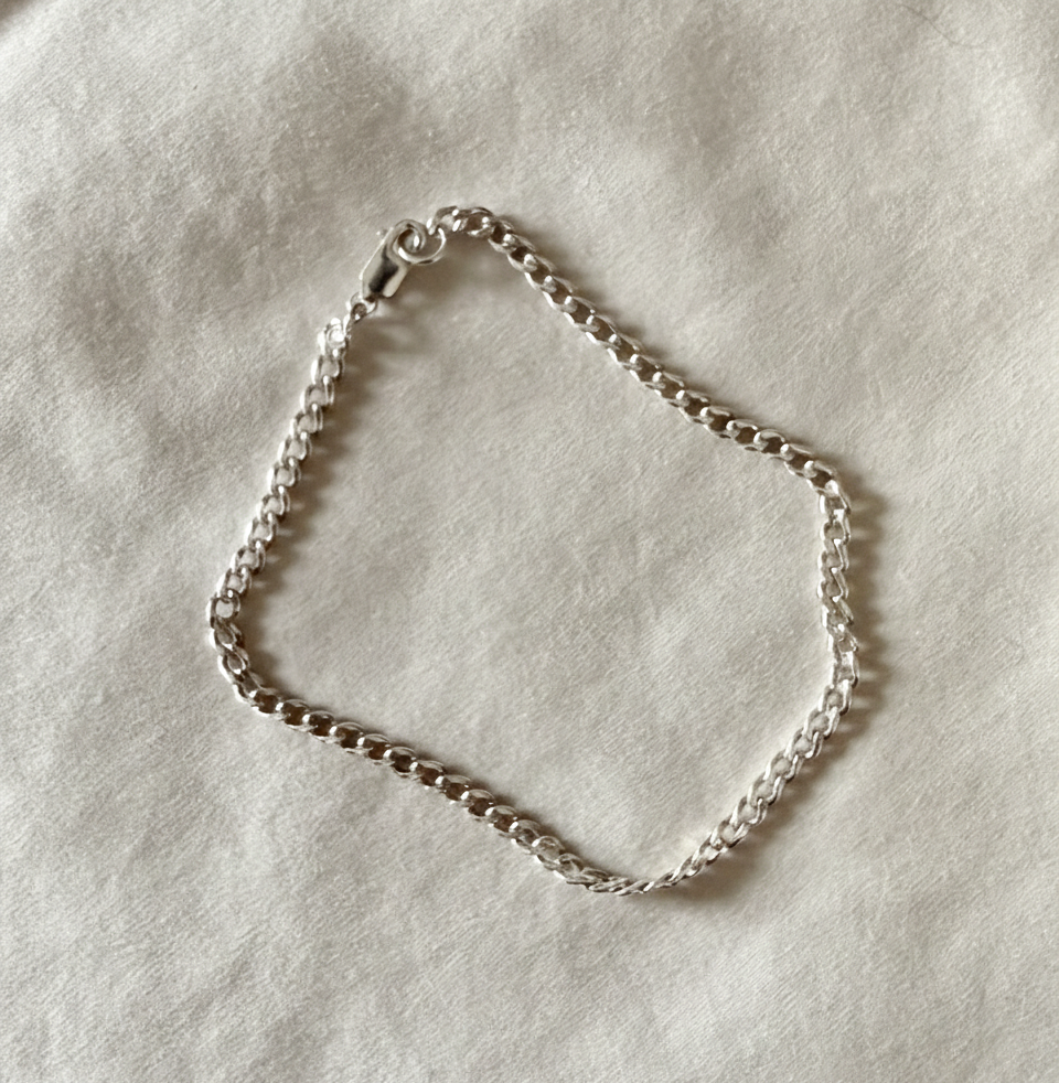 Silver chain bracelet on a light gray background