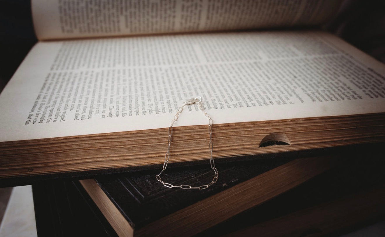 Small Silver paperclip bracelet  on an open book